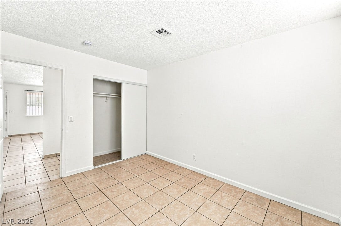 2553 Ellis Street, North Las Vegas, NV 89030 Tiled floors and built-in closet storage define this functional secondary bedroom.