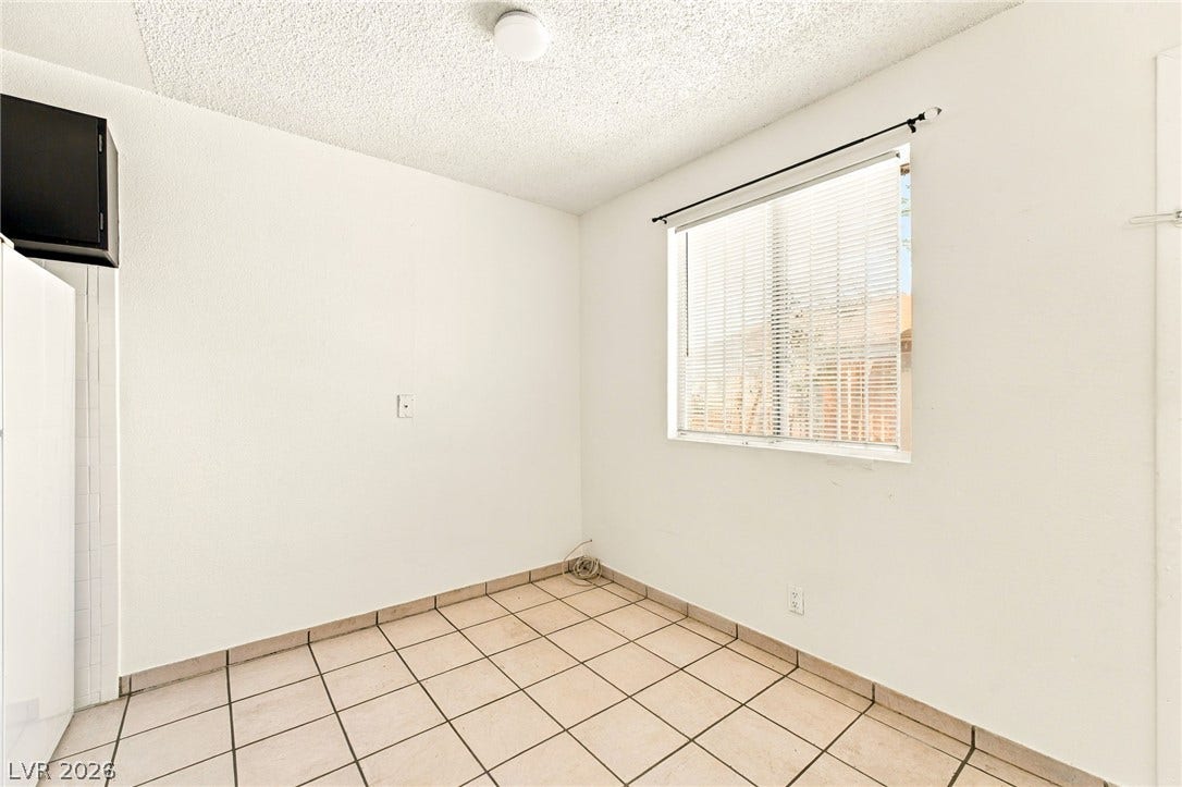 2553 Ellis Street, North Las Vegas, NV 89030 Tiled flooring pairs with a simple window in this versatile dining or utility space.