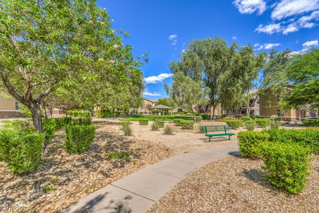 6868 Sky Pointe Drive, #1132, Las Vegas, NV 89131 A paved walkway winds through landscaped common areas under clear blue skies.