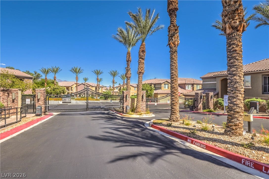6868 Sky Pointe Drive, #1132, Las Vegas, NV 89131 Secure gated entry welcomes residents with mature palm trees and professional desert landscaping.