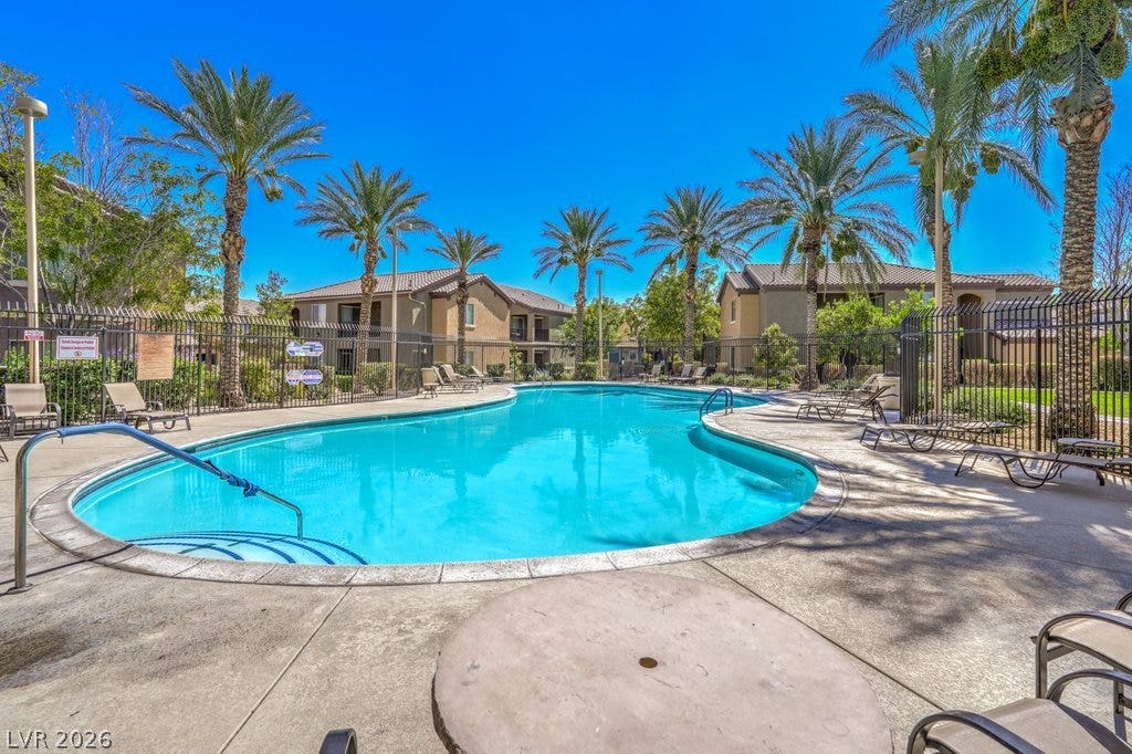 6868 Sky Pointe Drive, #1132, Las Vegas, NV 89131 Mature palm trees frame a sparkling community swimming pool surrounded by spacious concrete decking.