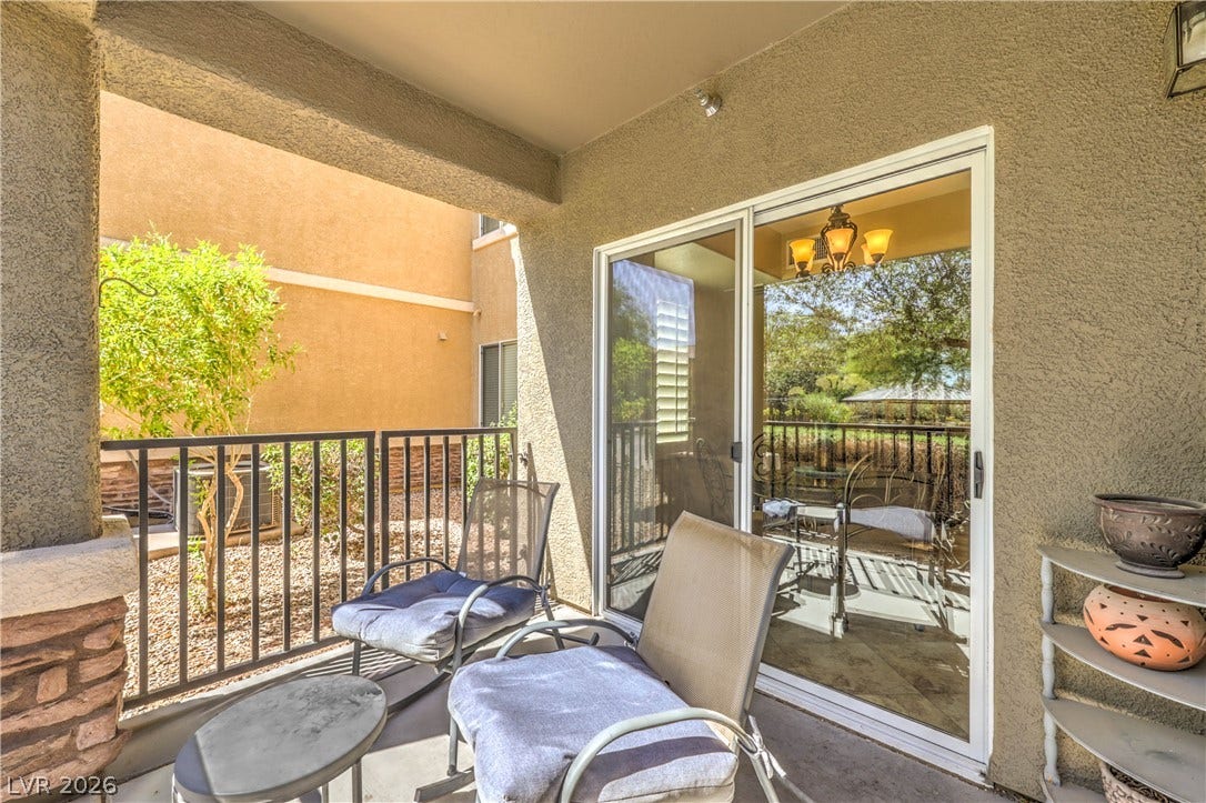 6868 Sky Pointe Drive, #1132, Las Vegas, NV 89131 Sliding glass doors open onto a private covered balcony with stone accent pillars.