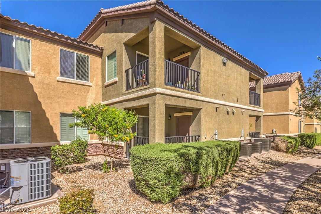 6868 Sky Pointe Drive, #1132, Las Vegas, NV 89131 Spanish tile roofing and textured stucco walls define this multi-level residential exterior.