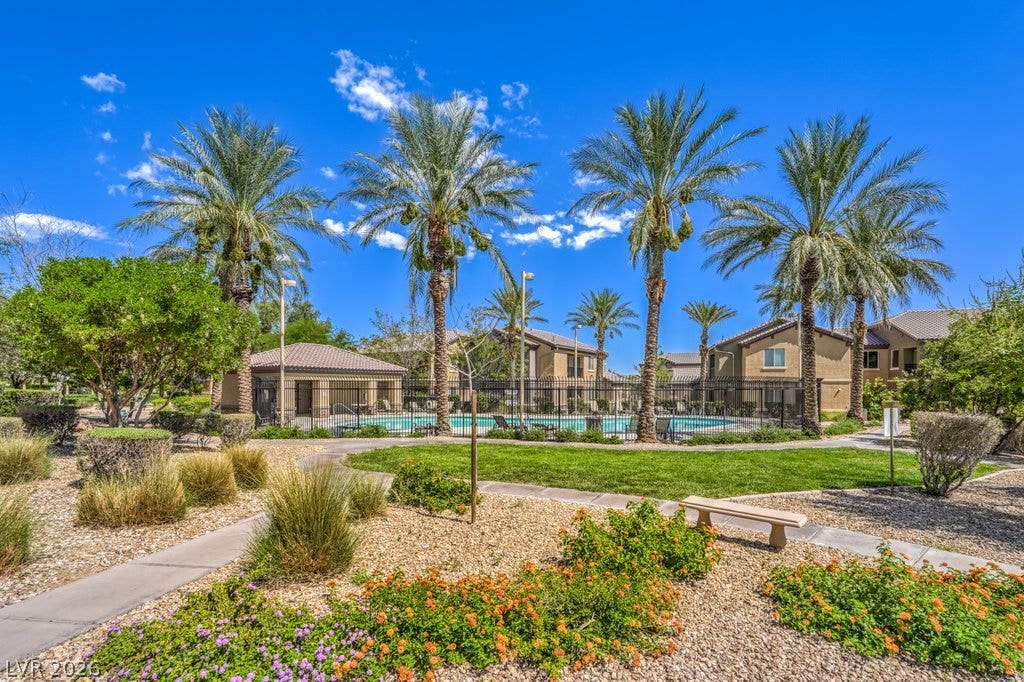 6868 Sky Pointe Drive, #1132, Las Vegas, NV 89131 Manicured pathways and mature palm trees surround a sparkling community swimming pool.
