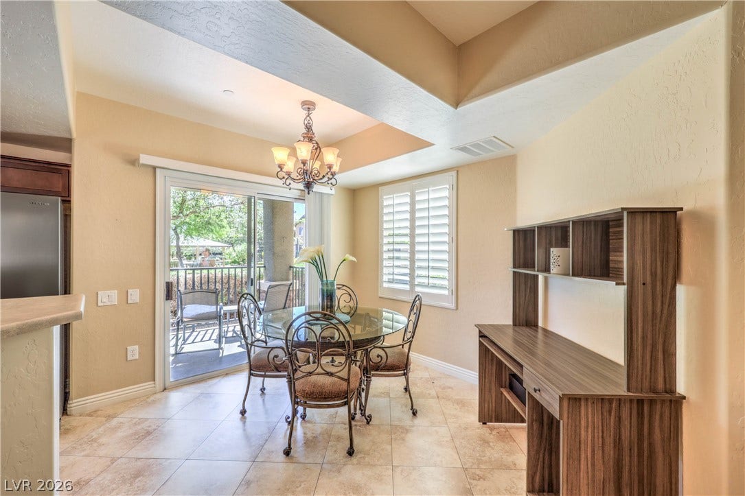 6868 Sky Pointe Drive, #1132, Las Vegas, NV 89131 Tiled floors and a recessed ceiling with a classic chandelier define this dining space.