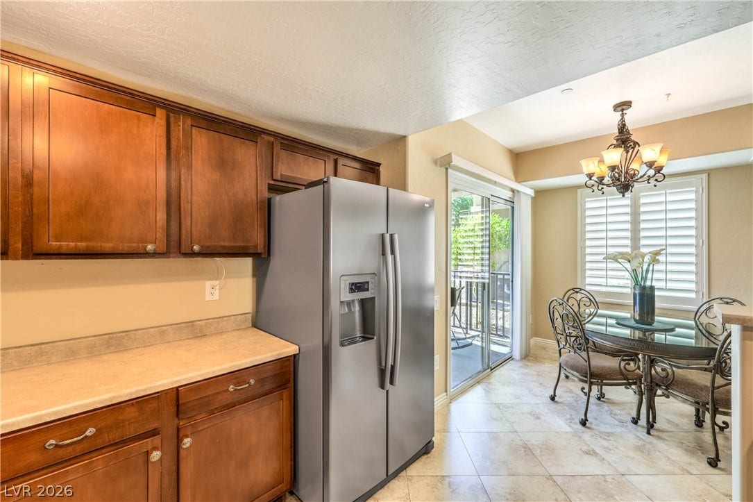 6868 Sky Pointe Drive, #1132, Las Vegas, NV 89131 Rich wood cabinetry and tile flooring flow seamlessly into a bright, windowed dining nook.