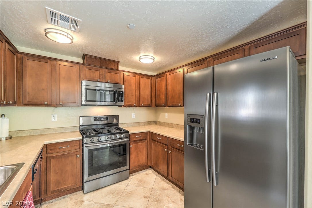 6868 Sky Pointe Drive, #1132, Las Vegas, NV 89131 Rich wood cabinetry and tile flooring define this functional cooking space.