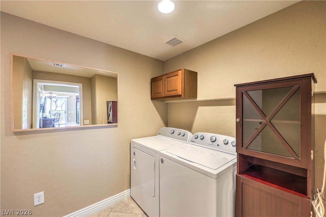 6868 Sky Pointe Drive, #1132, Las Vegas, NV 89131 Functional laundry setup includes upper cabinetry and tiled flooring.