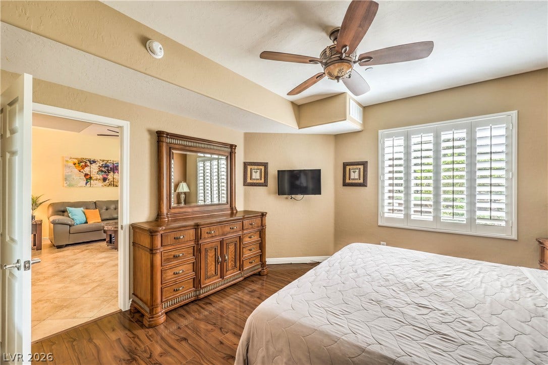 6868 Sky Pointe Drive, #1132, Las Vegas, NV 89131 Rich wood floors and plantation shutters define this comfortable, light-filled sleeping space.