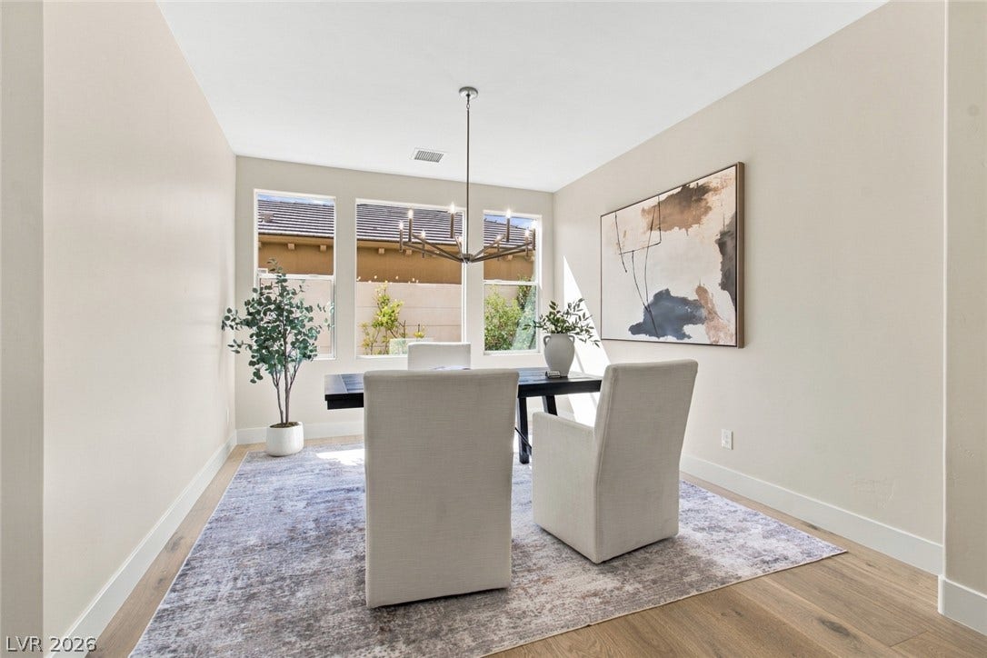 2837 Turtle Head Peak Drive, Las Vegas, NV 89135 A sunny dining room highlights hardwood floors and multiple large windows overlooking the yard.