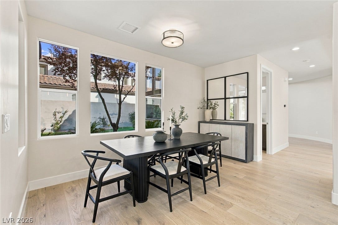 2837 Turtle Head Peak Drive, Las Vegas, NV 89135 Hardwood floors and tall windows define this light-filled modern dining space.