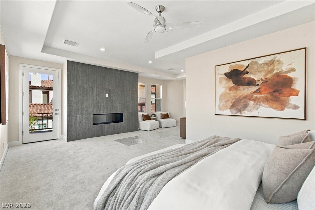 2837 Turtle Head Peak Drive, Las Vegas, NV 89135 An elegant tray ceiling and linear fireplace define this comfortable primary suite.