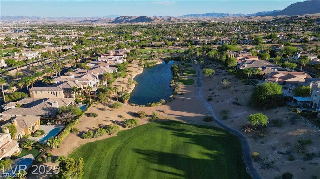 2837 Turtle Head Peak Drive, Las Vegas, NV 89135 An aerial perspective reveals a winding golf course green bordering a serene water feature.
