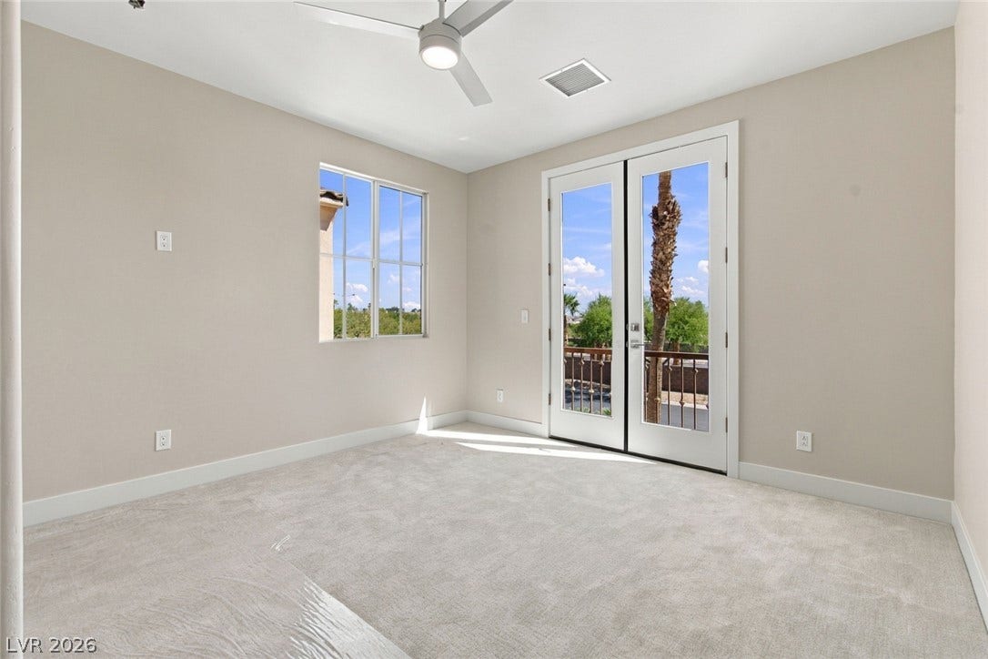 2837 Turtle Head Peak Drive, Las Vegas, NV 89135 Double glass doors open directly to a private balcony from this carpeted bedroom.