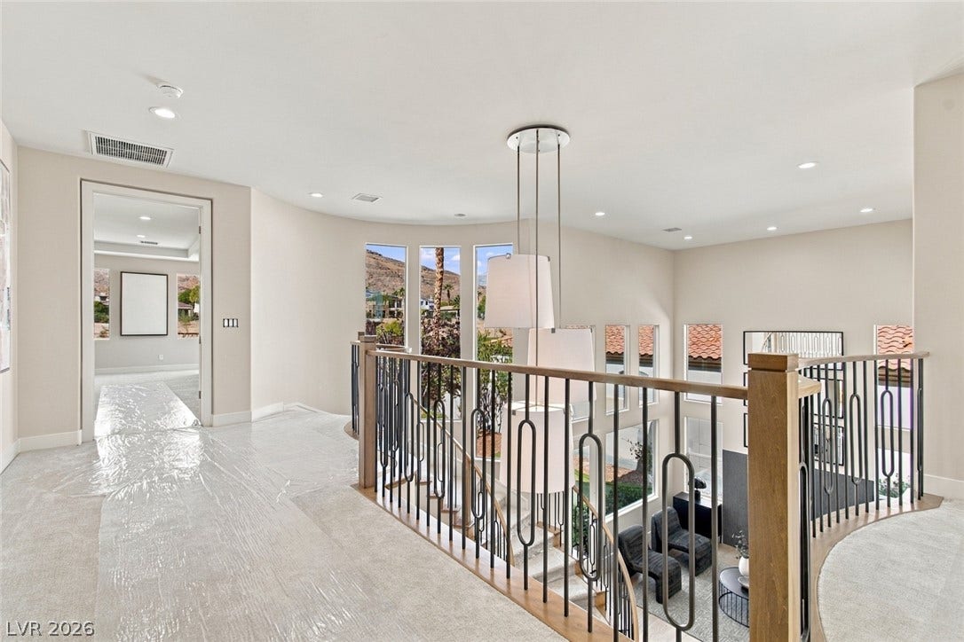 2837 Turtle Head Peak Drive, Las Vegas, NV 89135 A spacious upper-level landing overlooks the downstairs area through iron-railed banisters beneath recessed lighting.