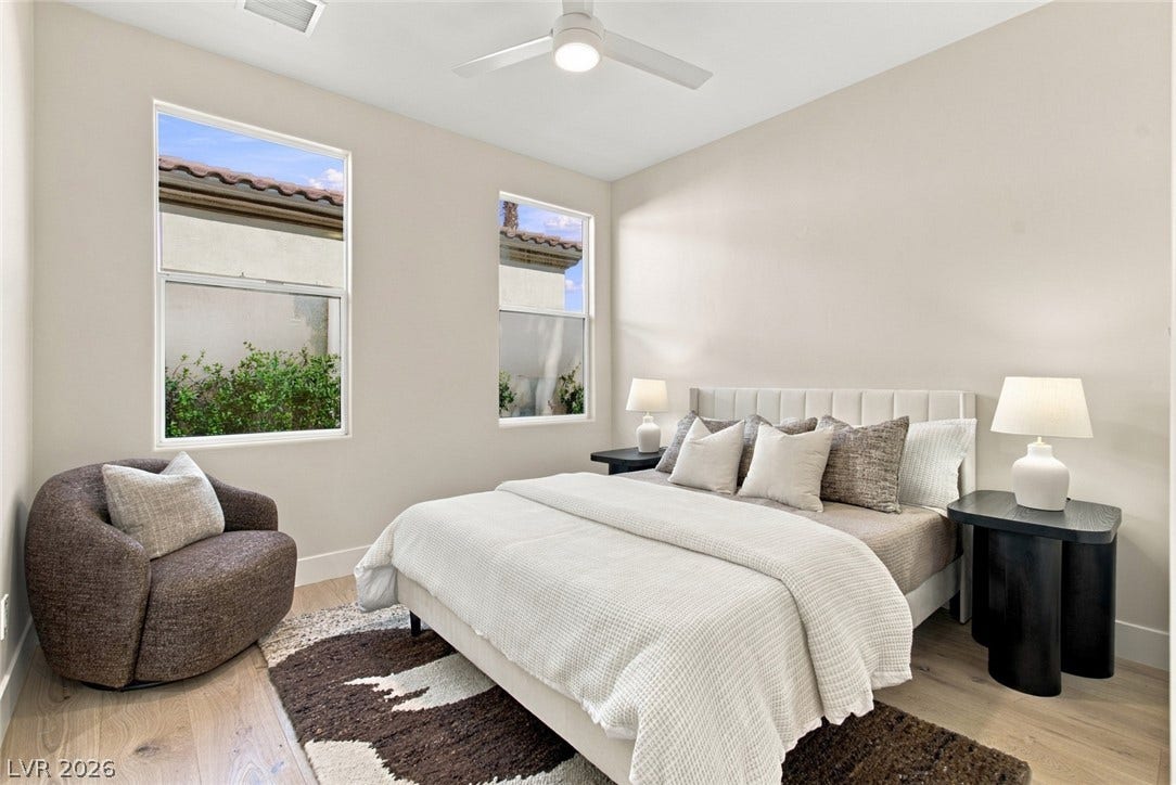 2837 Turtle Head Peak Drive, Las Vegas, NV 89135 Tall windows frame garden views in this serene bedroom with warm wood floors.