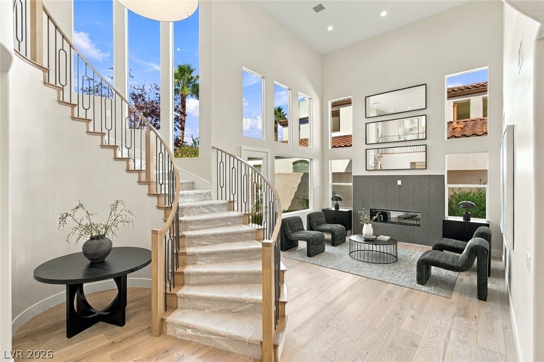2837 Turtle Head Peak Drive, Las Vegas, NV 89135 Soaring ceilings and a dramatic curved staircase define this light-filled double-height living pavilion.