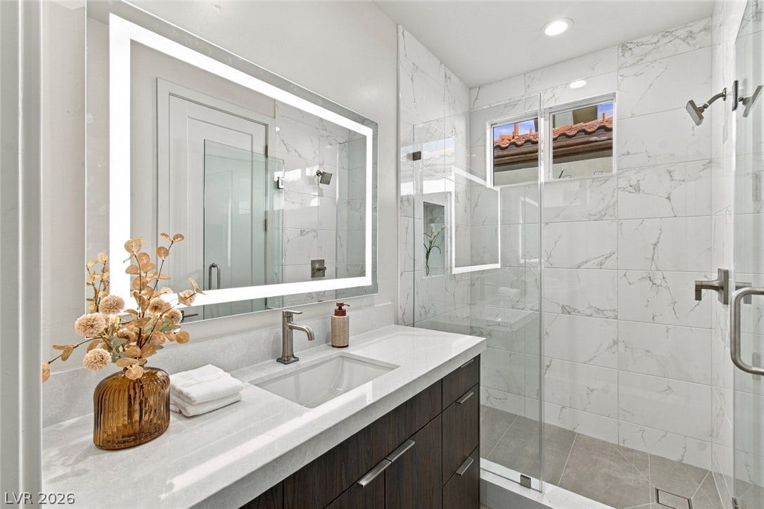 2837 Turtle Head Peak Drive, Las Vegas, NV 89135 Floor-to-ceiling marble-style tiling elevates this contemporary space with a glass-enclosed shower.