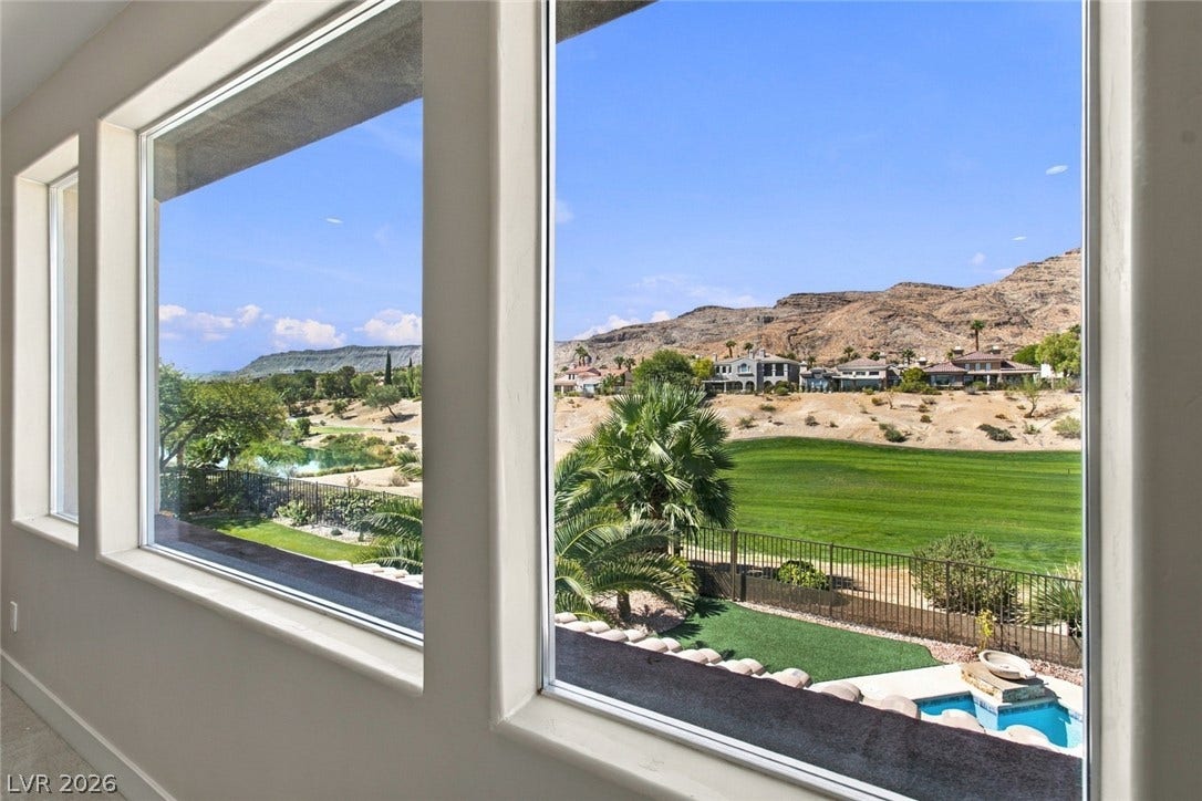 2837 Turtle Head Peak Drive, Las Vegas, NV 89135 Large windows frame picturesque desert mountains and a lush green golf course.