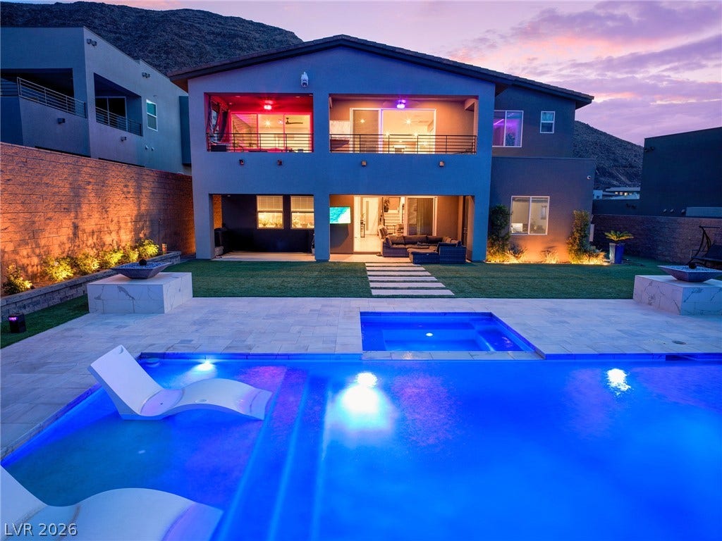 270 Shaded Canyon Drive, Henderson, NV 89012 An inviting backyard oasis features a glowing swimming pool alongside a modern multi-level residence.