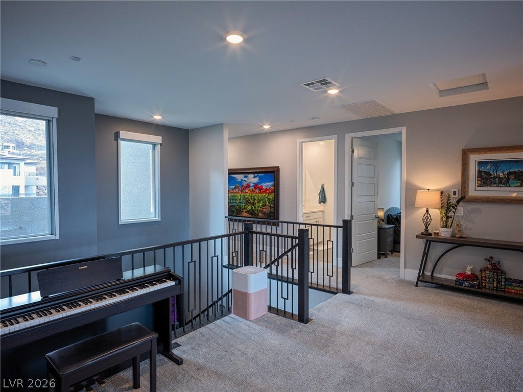 270 Shaded Canyon Drive, Henderson, NV 89012 Recessed lighting illuminates this upper landing featuring soft carpeting and a modern metal railing.