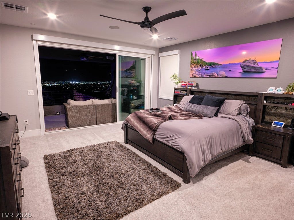 270 Shaded Canyon Drive, Henderson, NV 89012 Sliding glass doors open from this bedroom to a private balcony showcasing distant city views.