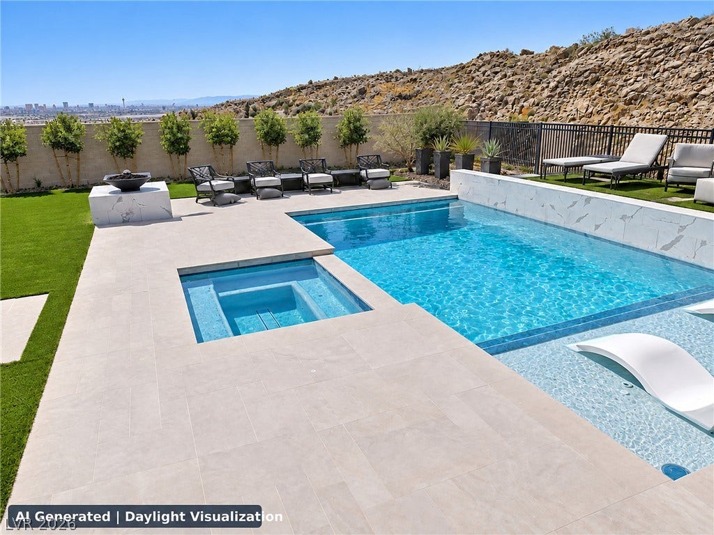 270 Shaded Canyon Drive, Henderson, NV 89012 Smooth stone decking frames a modern swimming pool and integrated spa against a rugged hillside backdrop.