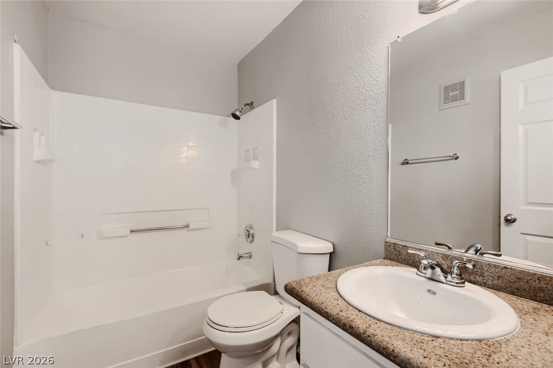 Granite counters and a clean tub shower combination define this modern bathroom.