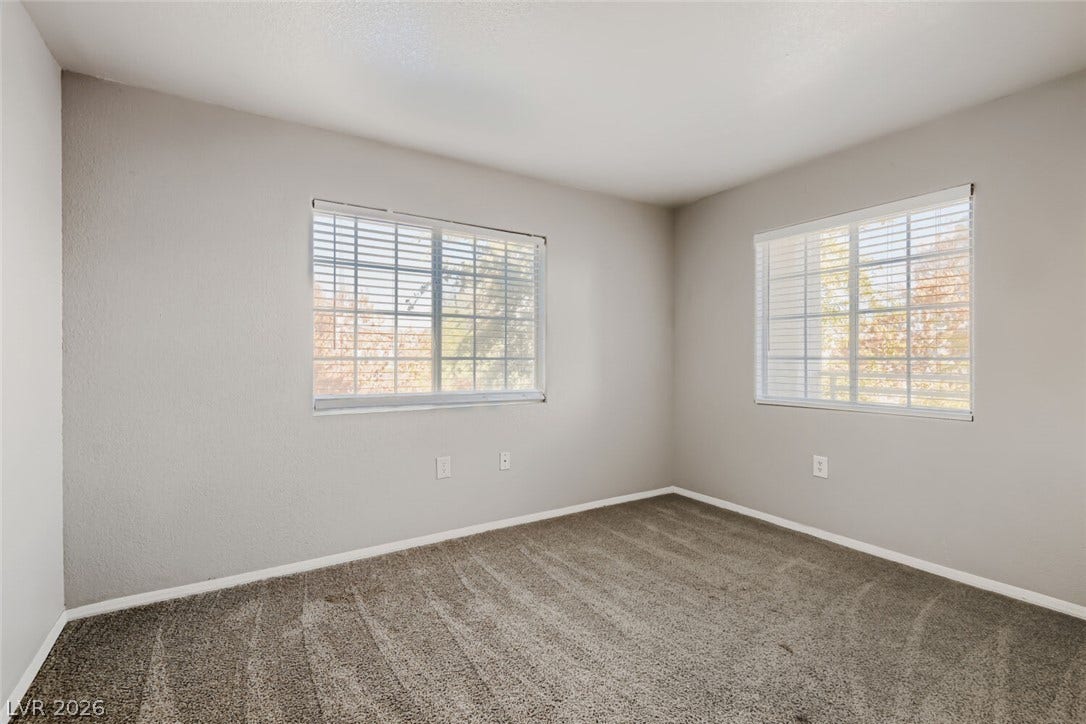 Natural light fills this bedroom complete with plush carpeting and dual windows.