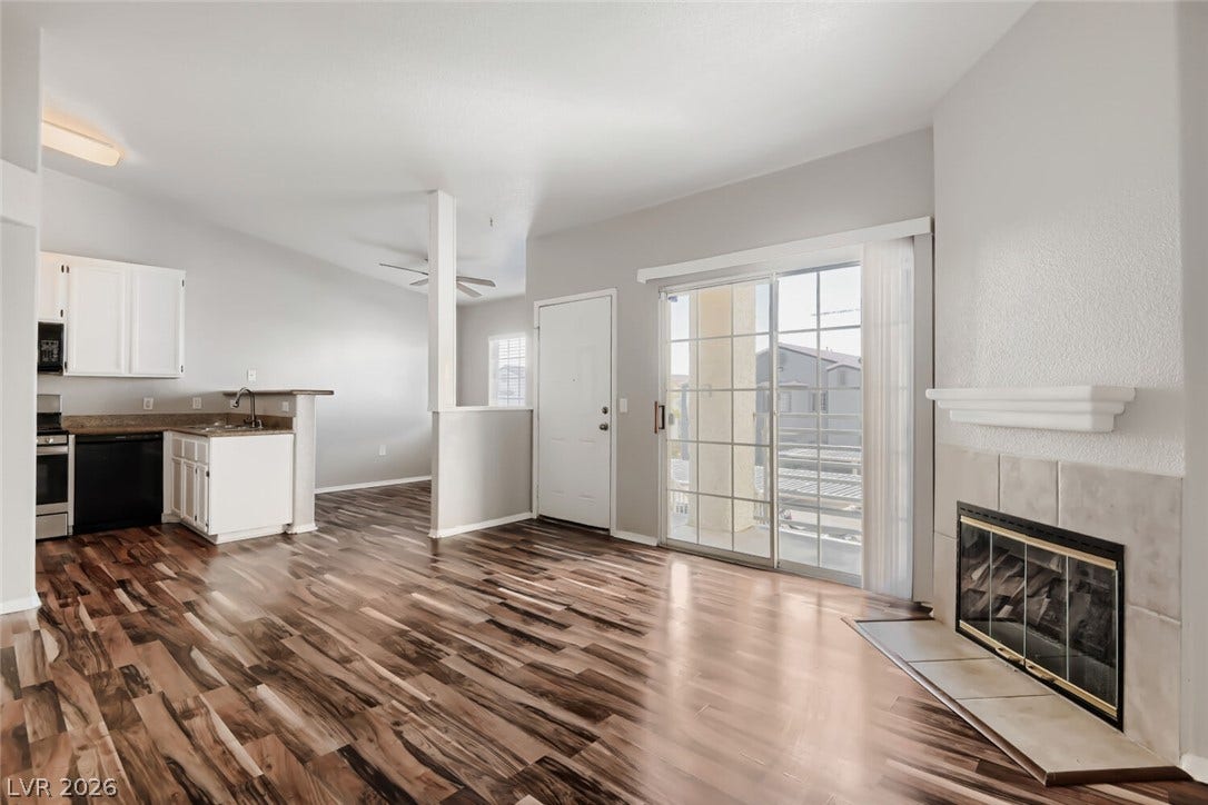 Gleaming hardwood floors and a classic tile fireplace anchor this inviting open living space.