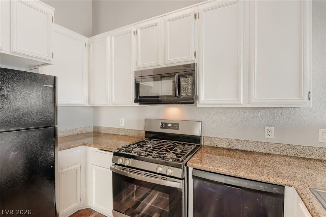Granite countertops and crisp white cabinetry define this highly functional culinary space.