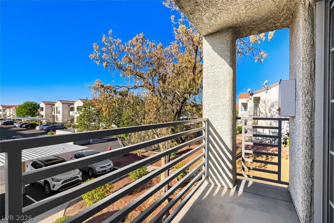 A private upper-level balcony overlooks mature trees and the surrounding neighborhood.