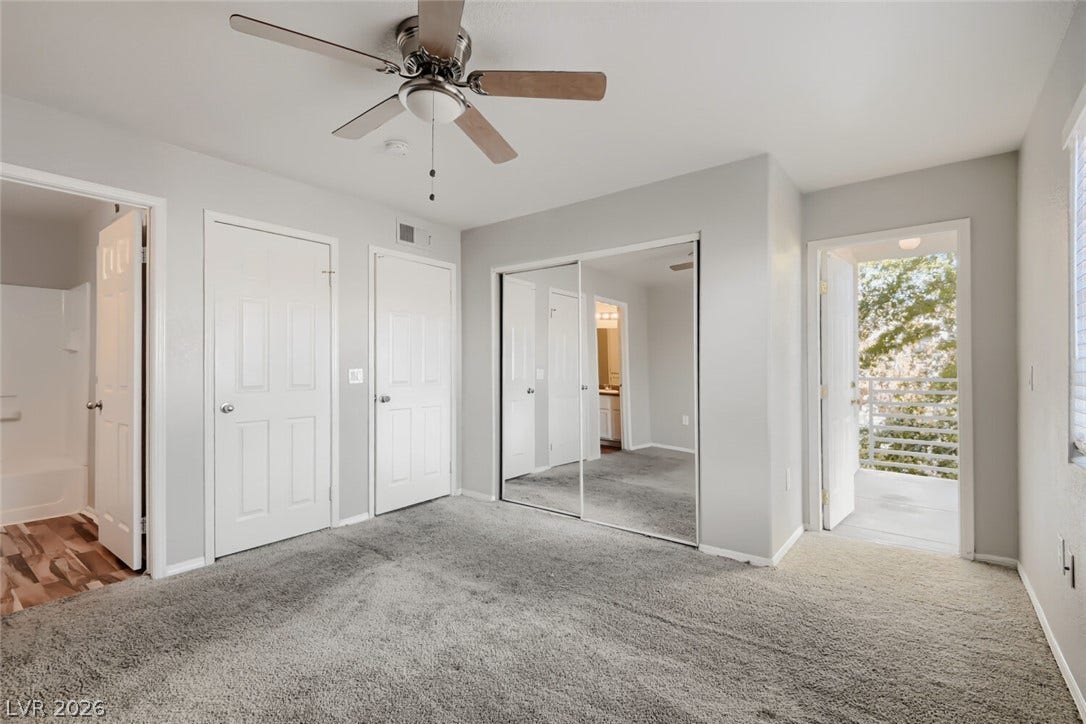 Plush carpeting and sliding mirrored closet doors highlight this comfortable bedroom space.