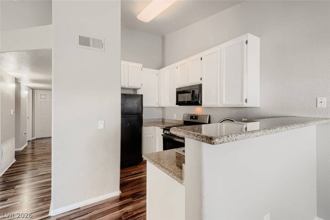 Polished stone counters and classic cabinetry define this functional culinary space.