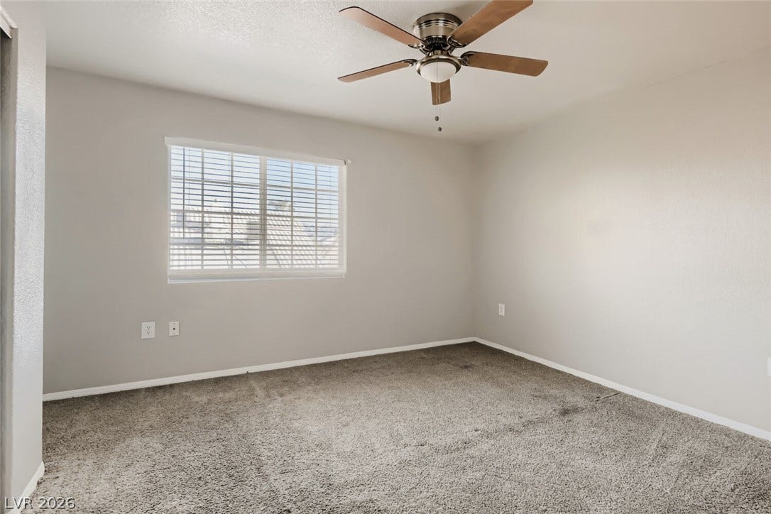 Soft carpeting pairs with a multi-pane window to create a comfortable, neutral retreat.