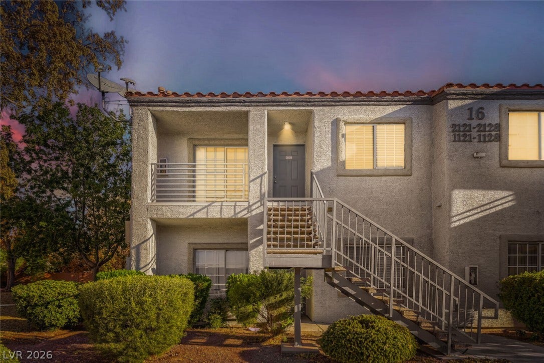 Spanish tile accents and a welcoming exterior staircase define this multi-level residential structure.