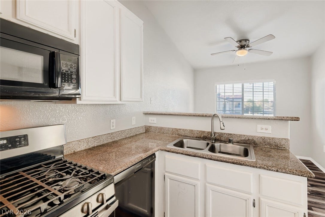 Polished granite countertops and classic cabinetry define this functional, open-concept cooking space.