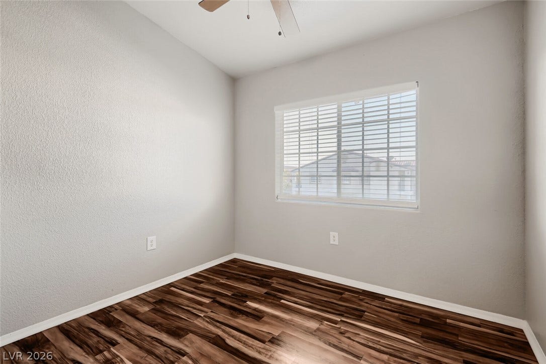 Gleaming hardwood floors and a wide window create a welcoming atmosphere in this room.