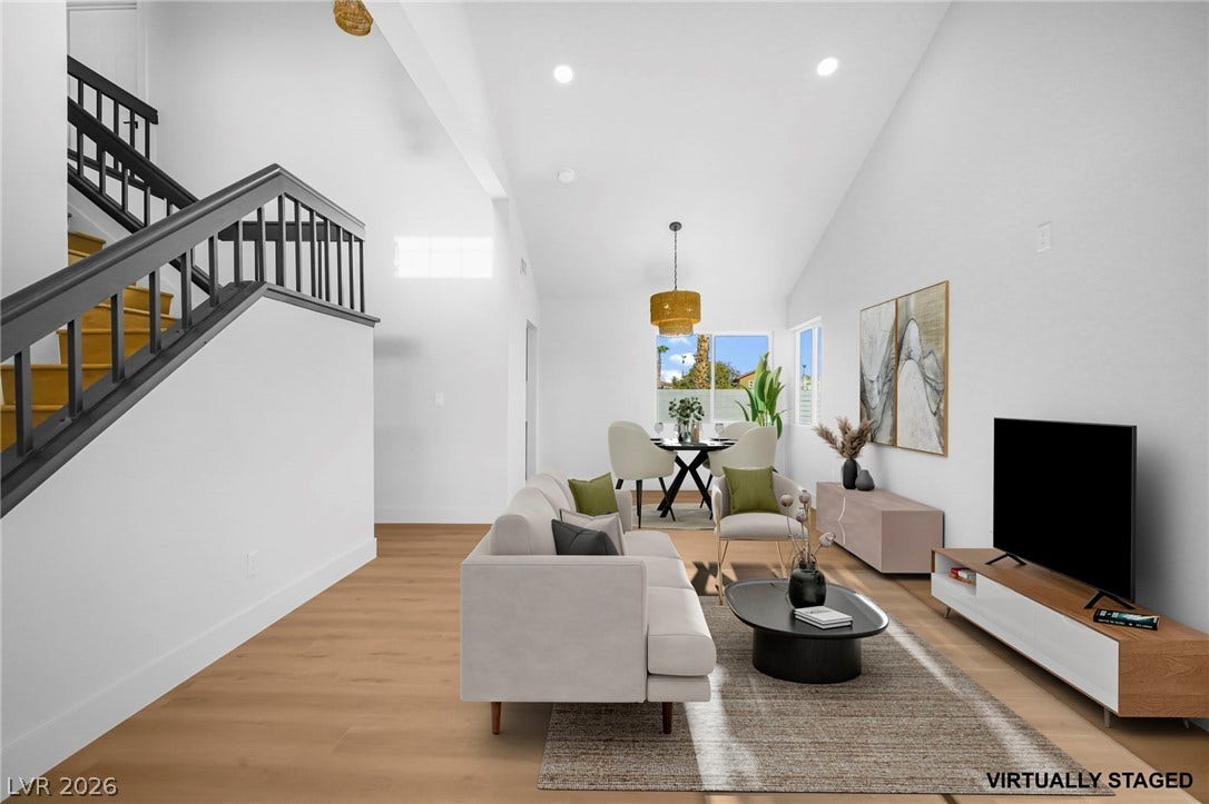 High vaulted ceilings and rich wood floors define this airy open-concept living space.