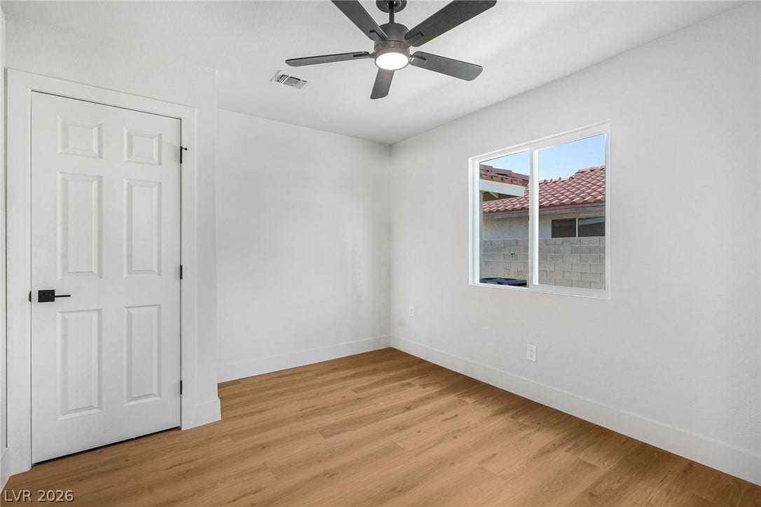 Rich wood-plank flooring and crisp white walls create a clean canvas in this versatile room.