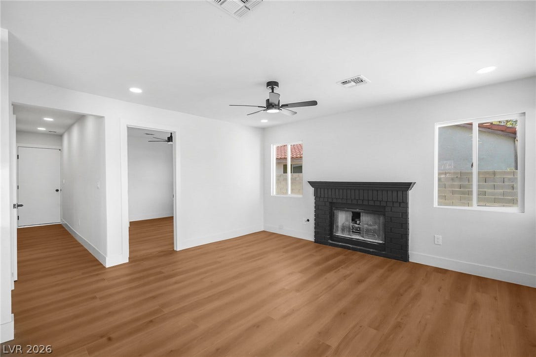 Rich wood floors anchor this open living area featuring a modern brick fireplace.