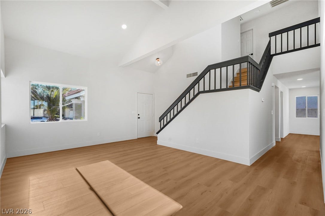 High ceilings and clean architectural lines define this welcoming entryway and staircase.