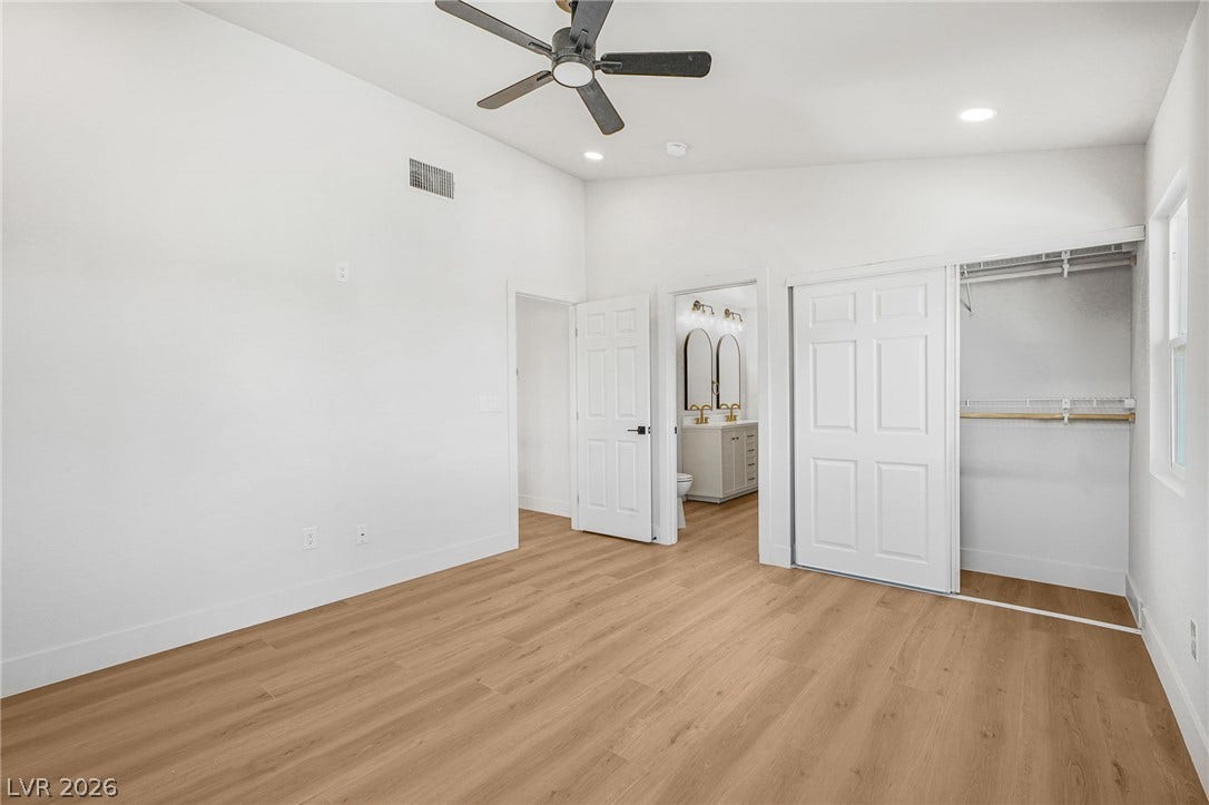 Clean lines and warm wood-style flooring define this modern bedroom space.