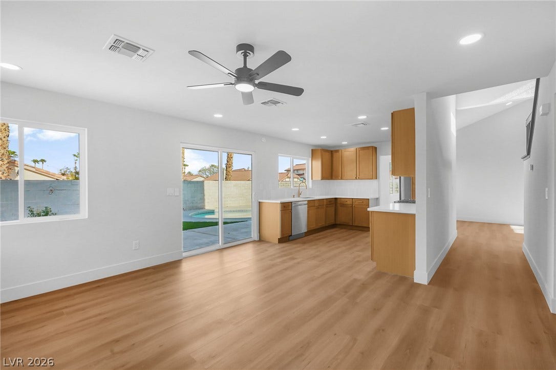 Smooth wood floors and sliding glass doors create a seamless flow to the backyard.