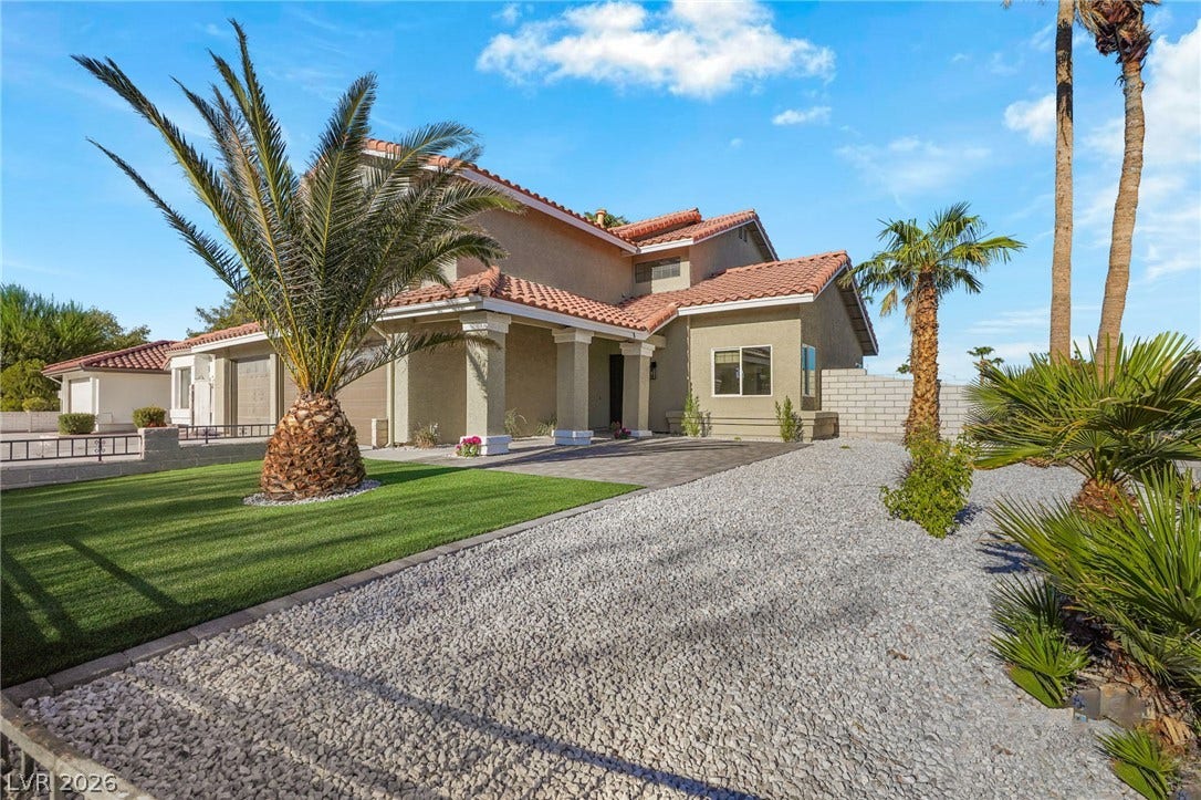 Stately stucco columns and a classic tile roof define this desert landscape entryway.