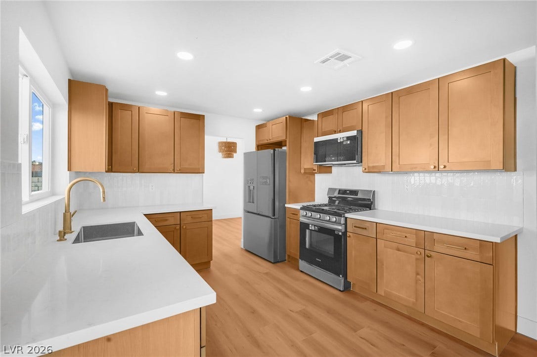 Gleaming stone countertops and warm wood cabinets define this modern culinary workspace.