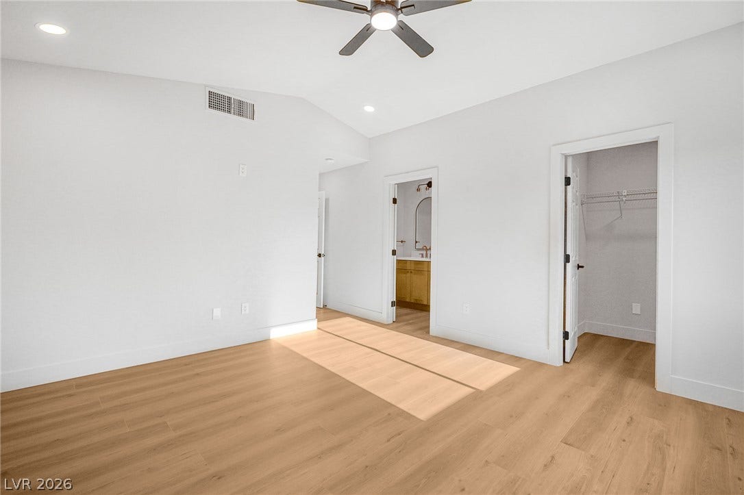 Smooth wood floors and vaulted ceilings create an open, airy feeling in this bedroom.