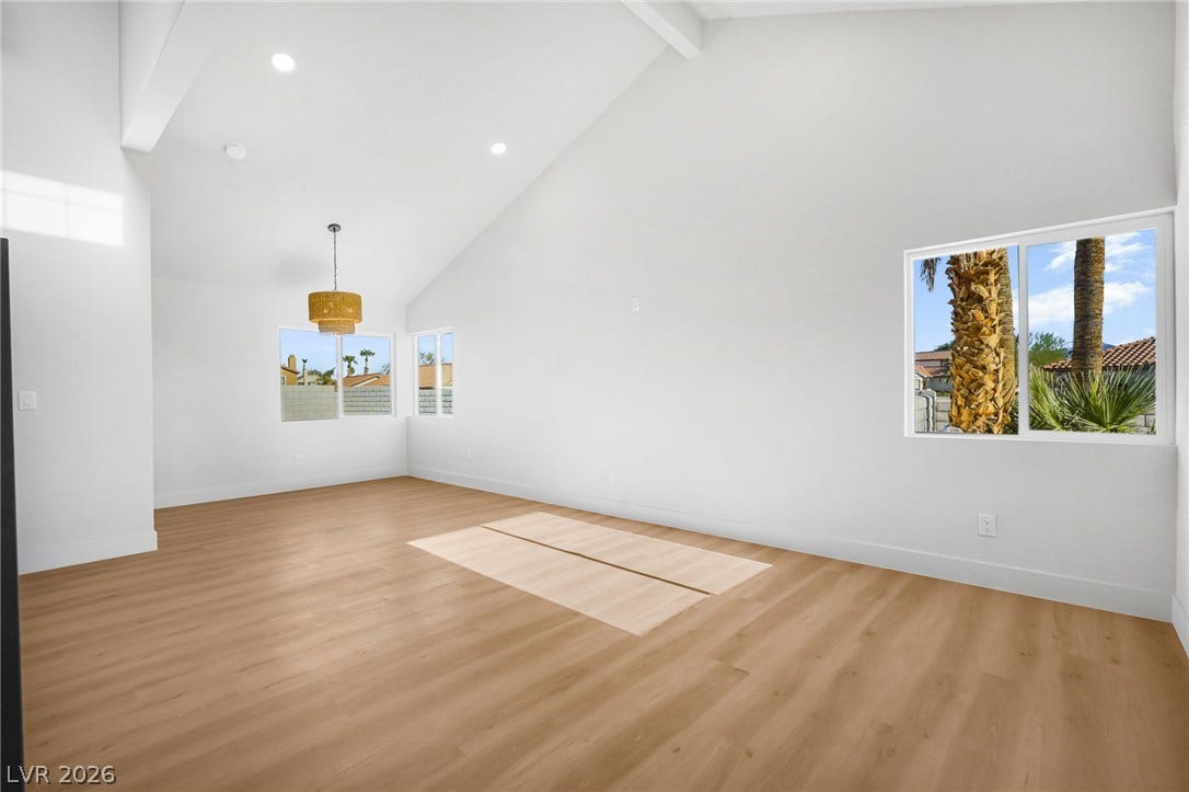 Vaulted ceilings and warm wood-style flooring create an open, airy living space.