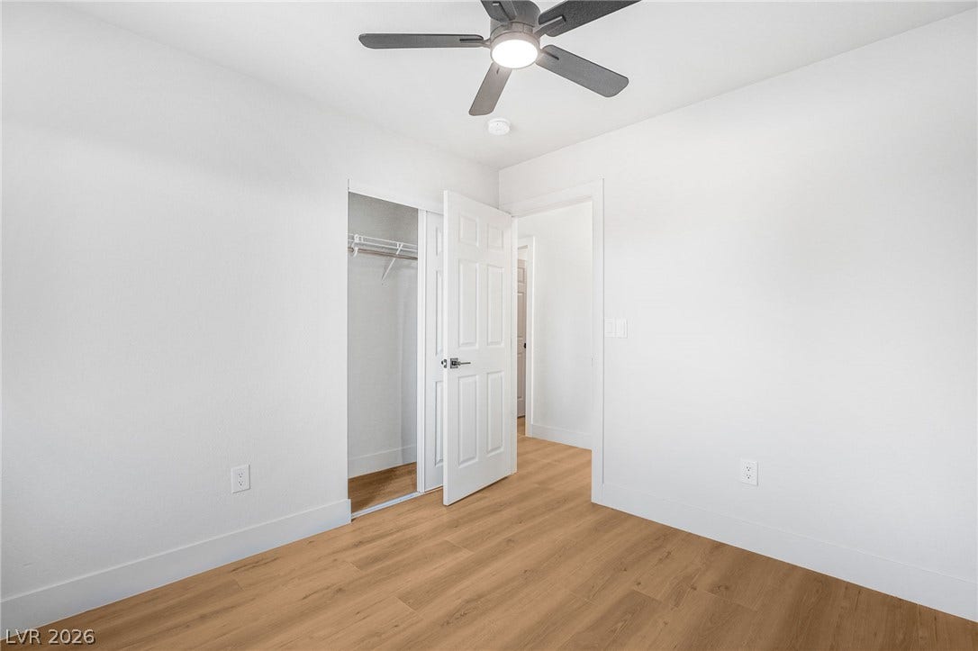 Gleaming wood floors anchor this minimalist room with clean walls and an open closet.
