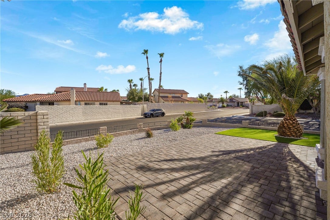 An inviting paved patio overlooks the meticulously landscaped desert yard.